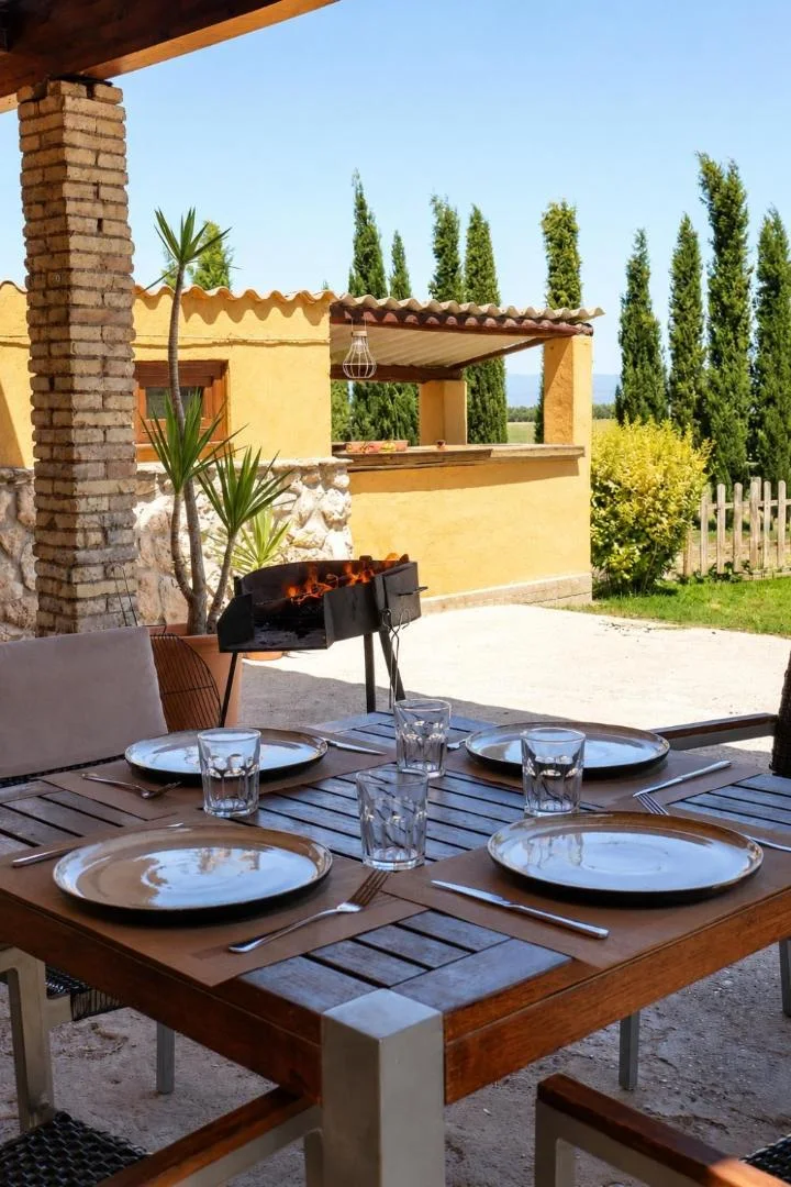 Barbacoa y mesa puesta en el porche