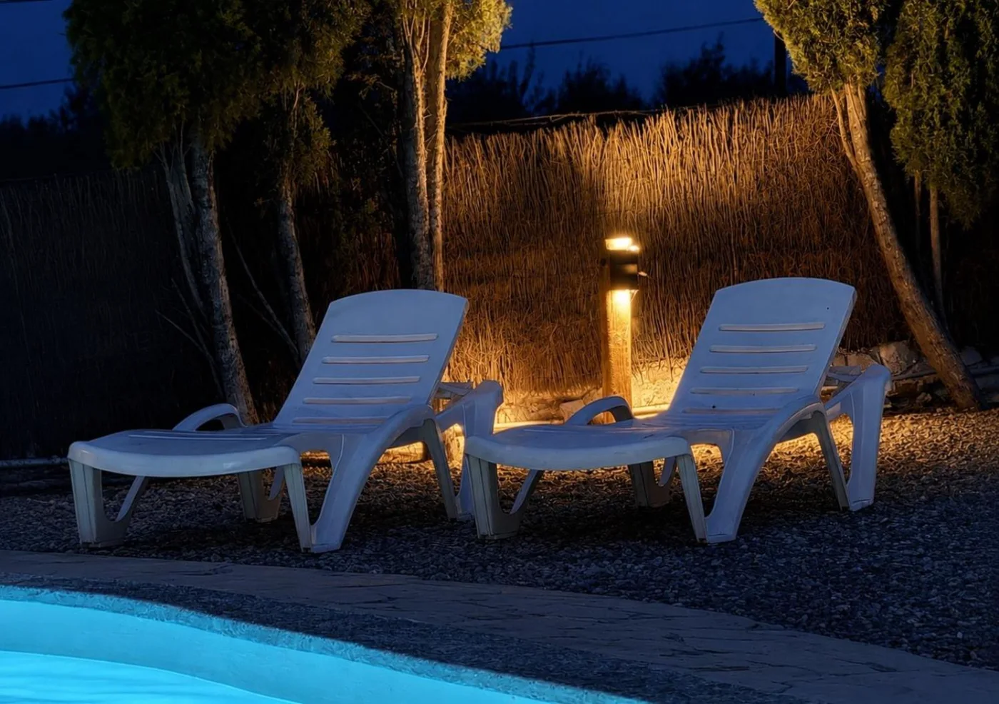 Tumbonas junto a la piscina al anochecer